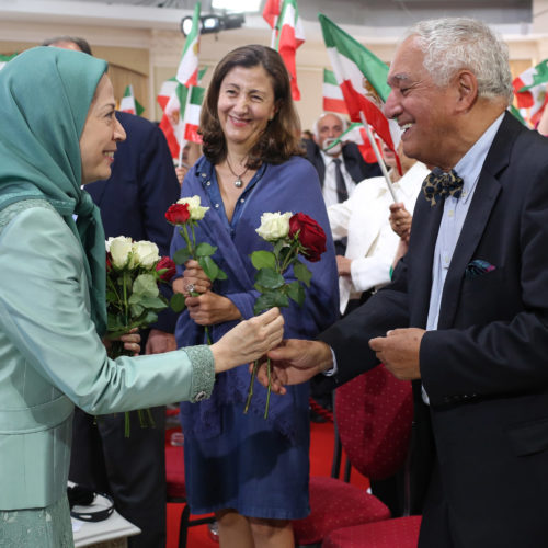 Maryam Rajavi offers flowers to political dignitaries at the celebration of the Relocation of Camp Liberty residents