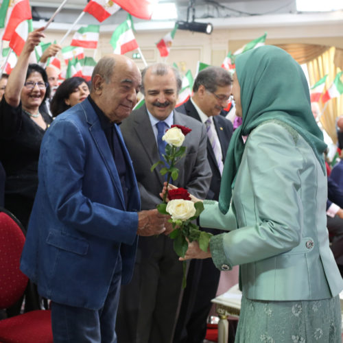 Maryam Rajavi offers flowers to political dignitaries at the celebration of the Relocation of Camp Liberty residents