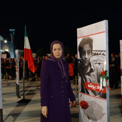 Pinning a rose to the portrait of the teenage martyr of the uprising, Javad Pousheh