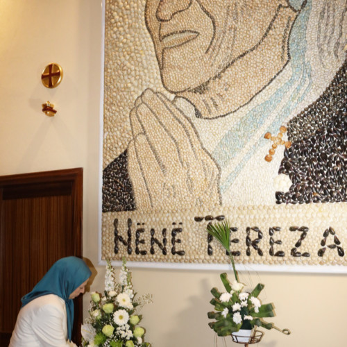 Offering flowers to the portrait of Mother Theresa at Saint Paul Cathedral, Tirana